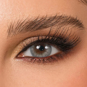 DYE Stardust Monthly Lenses by Bella in a clear case, showing a sparkling, grey-blue contact lens.