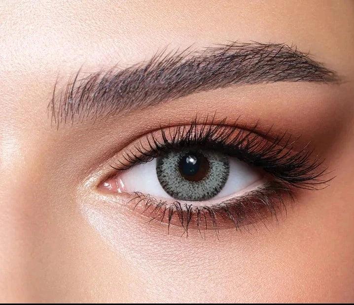 Bella Glow Husky Gray Green Lenses, showing a close-up of a gray-green contact lens with subtle gray flecks.