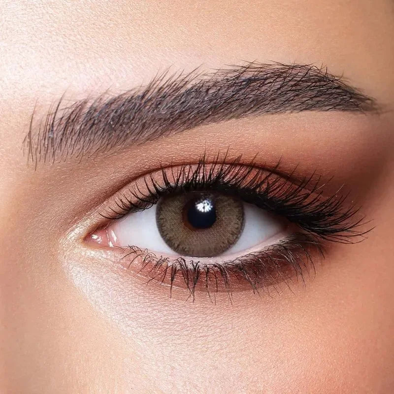 Bella Elite Green Olive Lenses, a pair of vibrant green contact lenses with a subtle olive hue, displayed in their packaging.