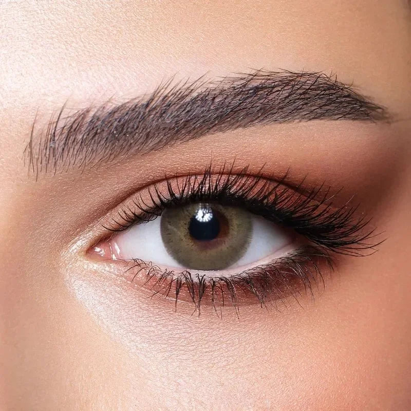 Bella Elite Silky Green Lenses in a clear case, showcasing their vibrant green hue and subtle pattern.