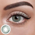 Unspoken Green 1 Yearly Lenses, a pair of vibrant green contact lenses on a white background.